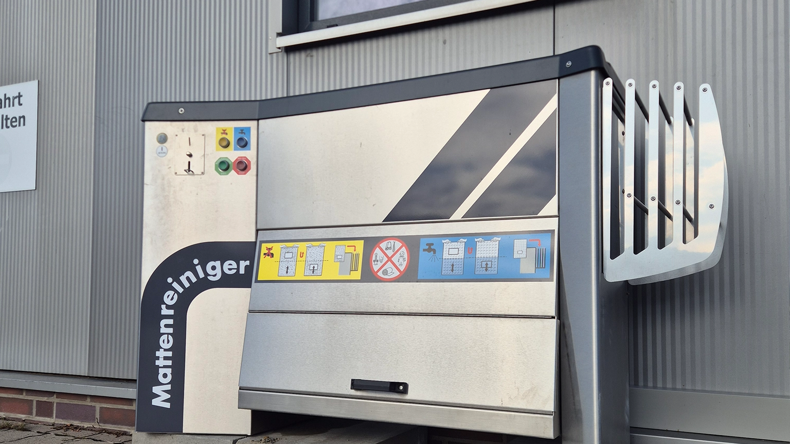 Automatischer Mattenreiniger an der Außenwand der Waschhalle